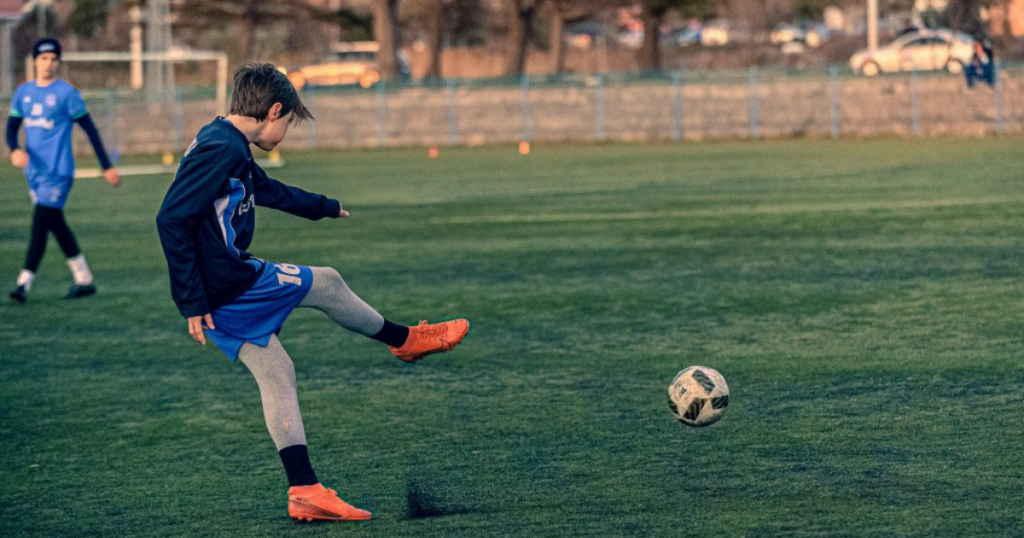 Young football player practicing during youth football training, representing the dedication and development behind future football talent.